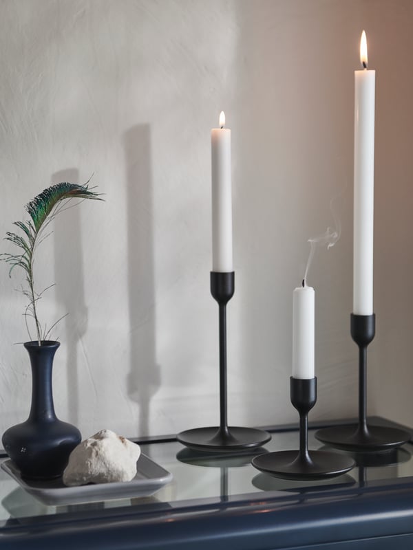 FULLTALIG candle holders on a cupboard with white JUBLA candles in front of a beige background