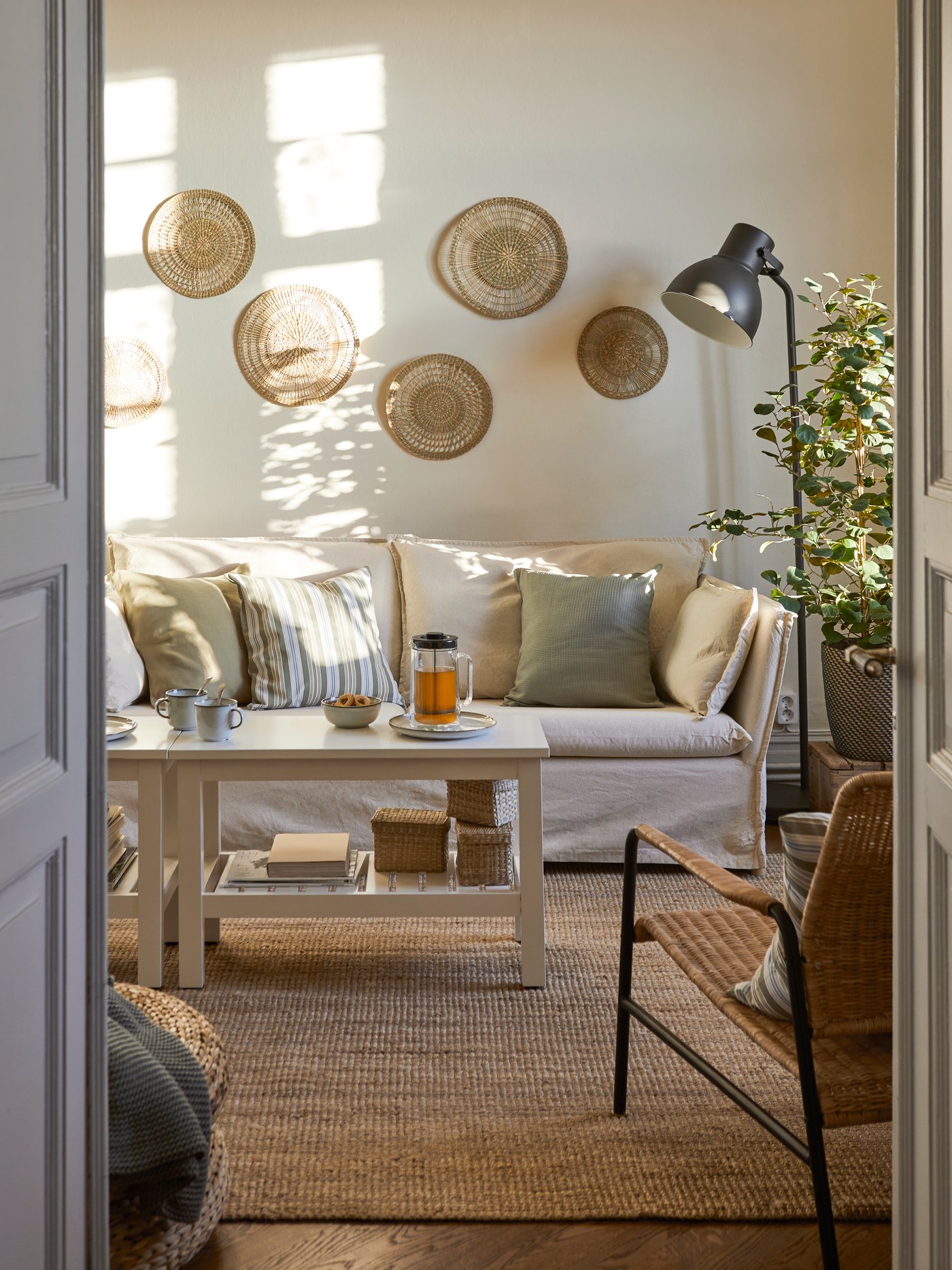 A bohemian-style living room with a light-coloured sofa and rattan wall décor.