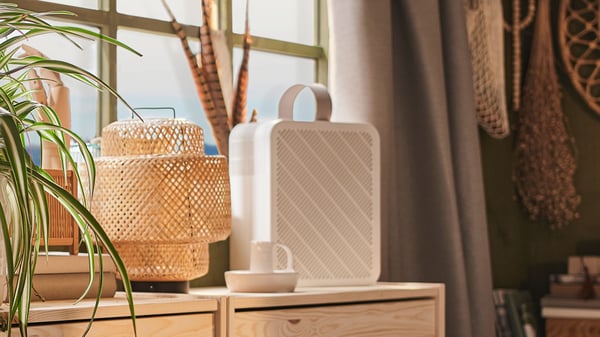 A UPPÅTVIND air purifier next to a bamboo SINNERLIG table lamp.