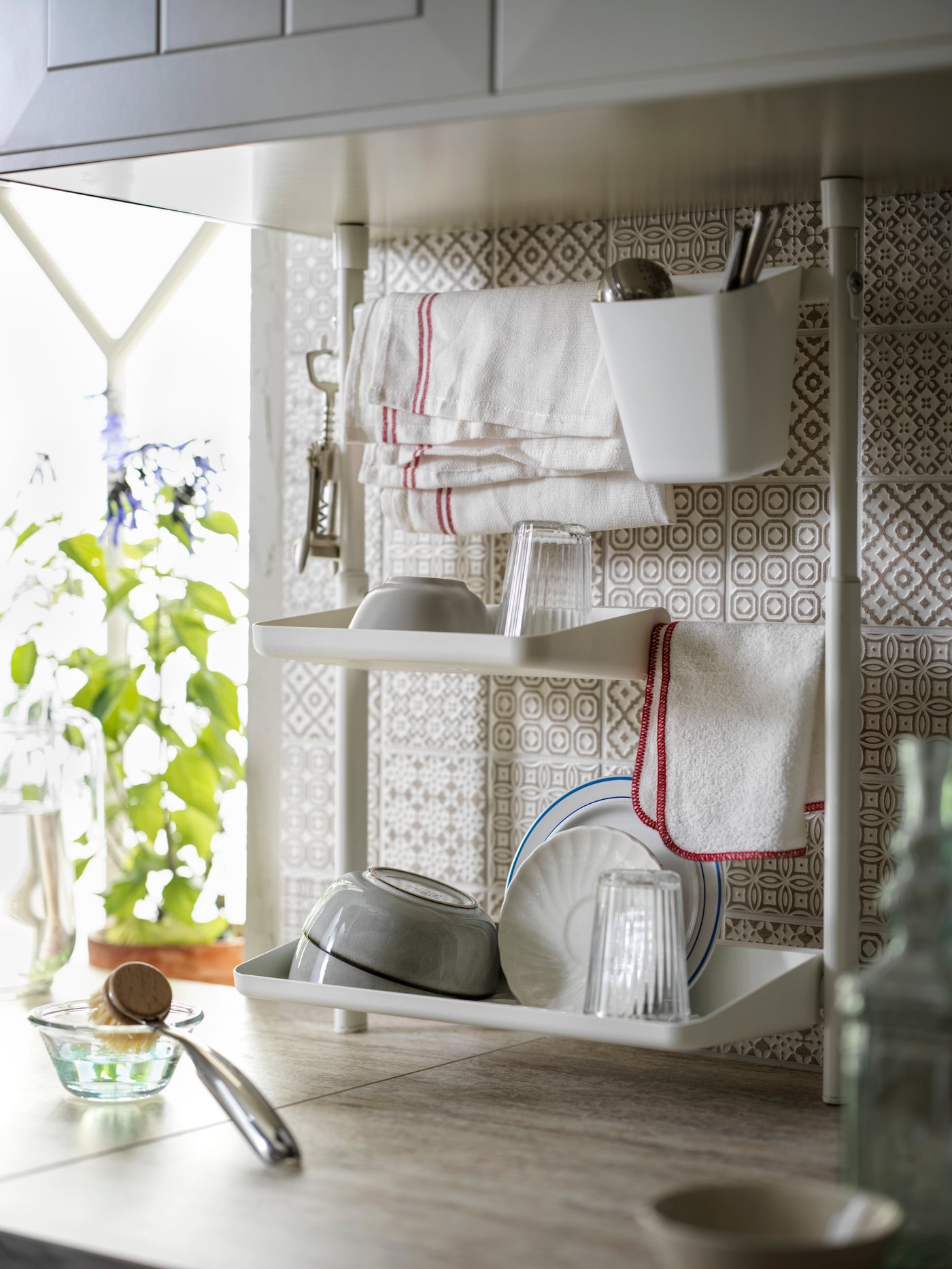 A SUNNERSTA kitchen organiser set filled with drying tableware and washing-up accessories.