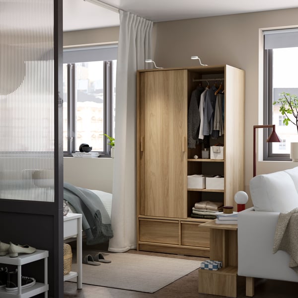 An oak effect ANKARUDDEN wardrobe with sliding doors in the bedroom
