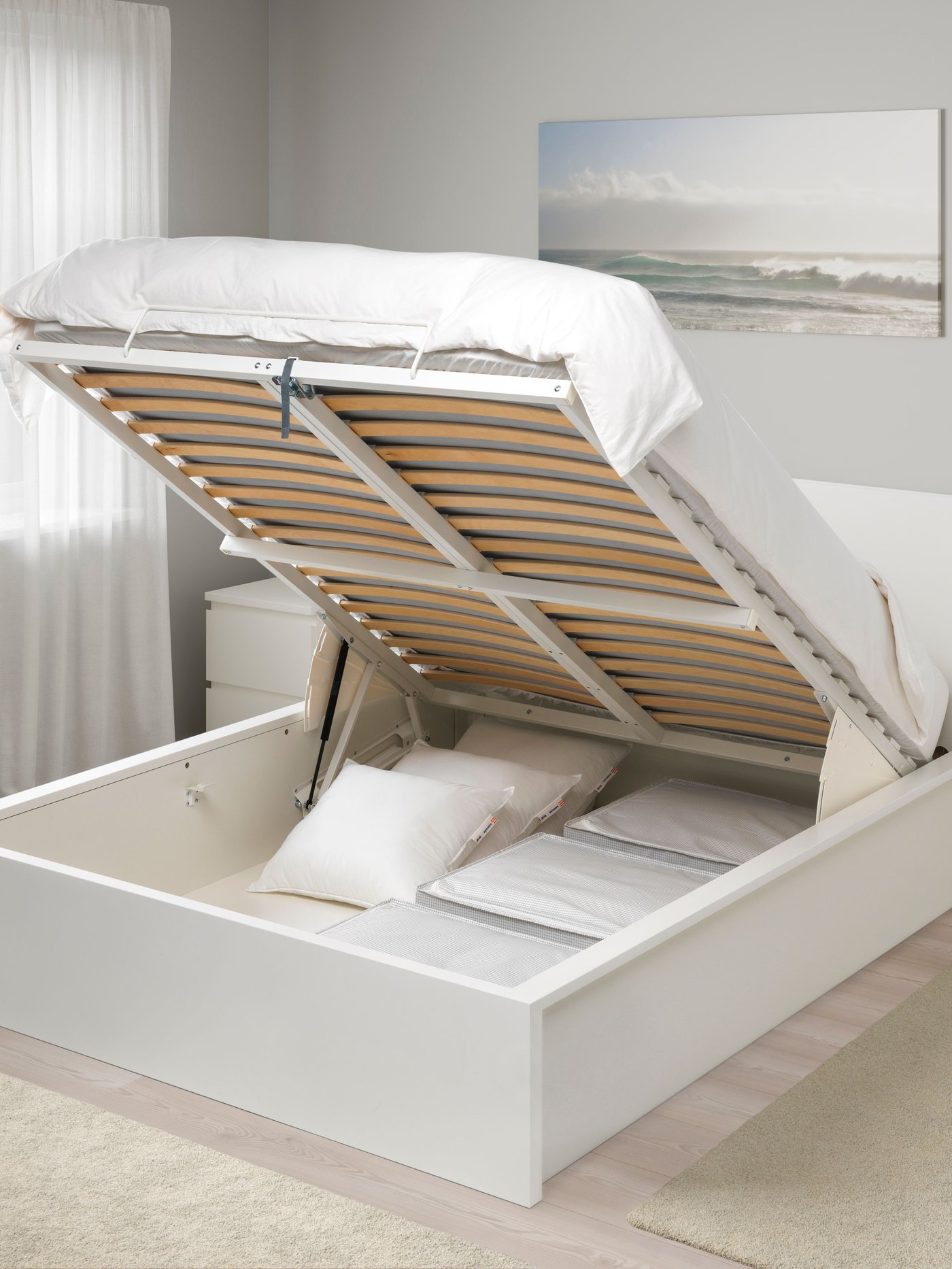 Una cama con almacenaje blanca MALM.