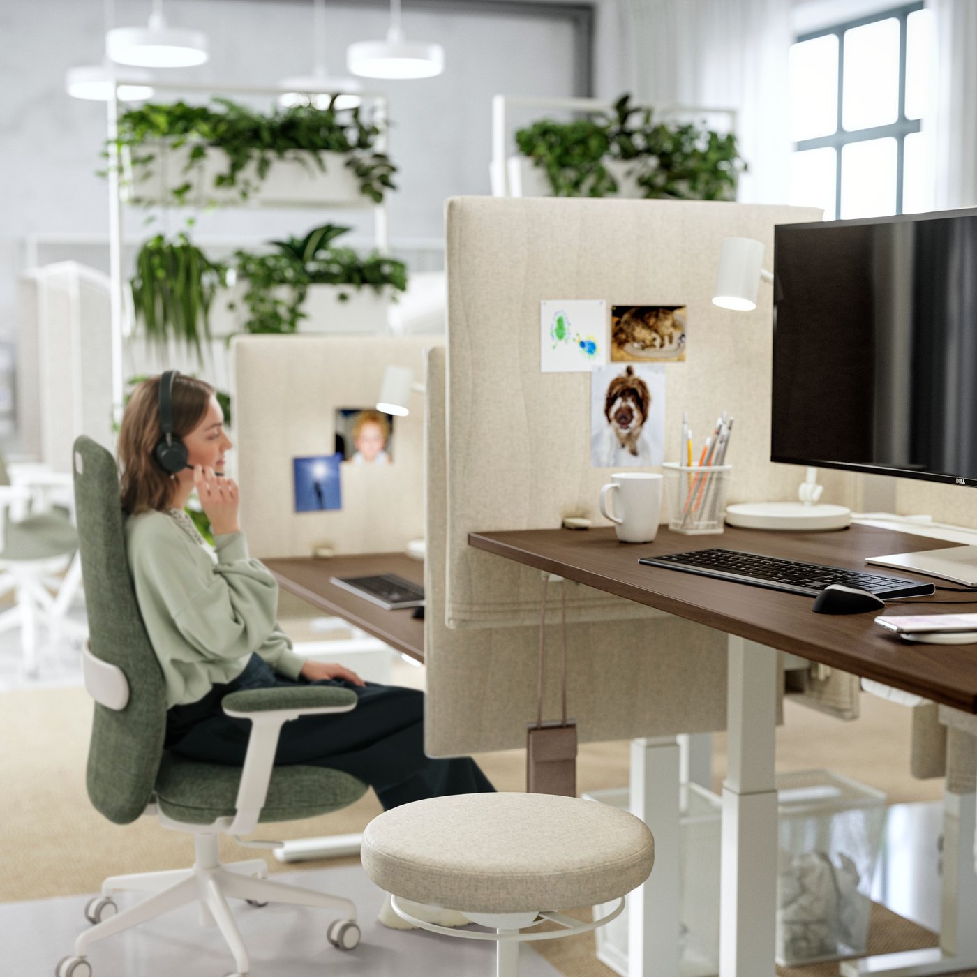 A dynamic workspace with a LIDKULLEN sit/stand support and a women in a GRÖNFJÄLL office chair in Letafors grey-green/white.