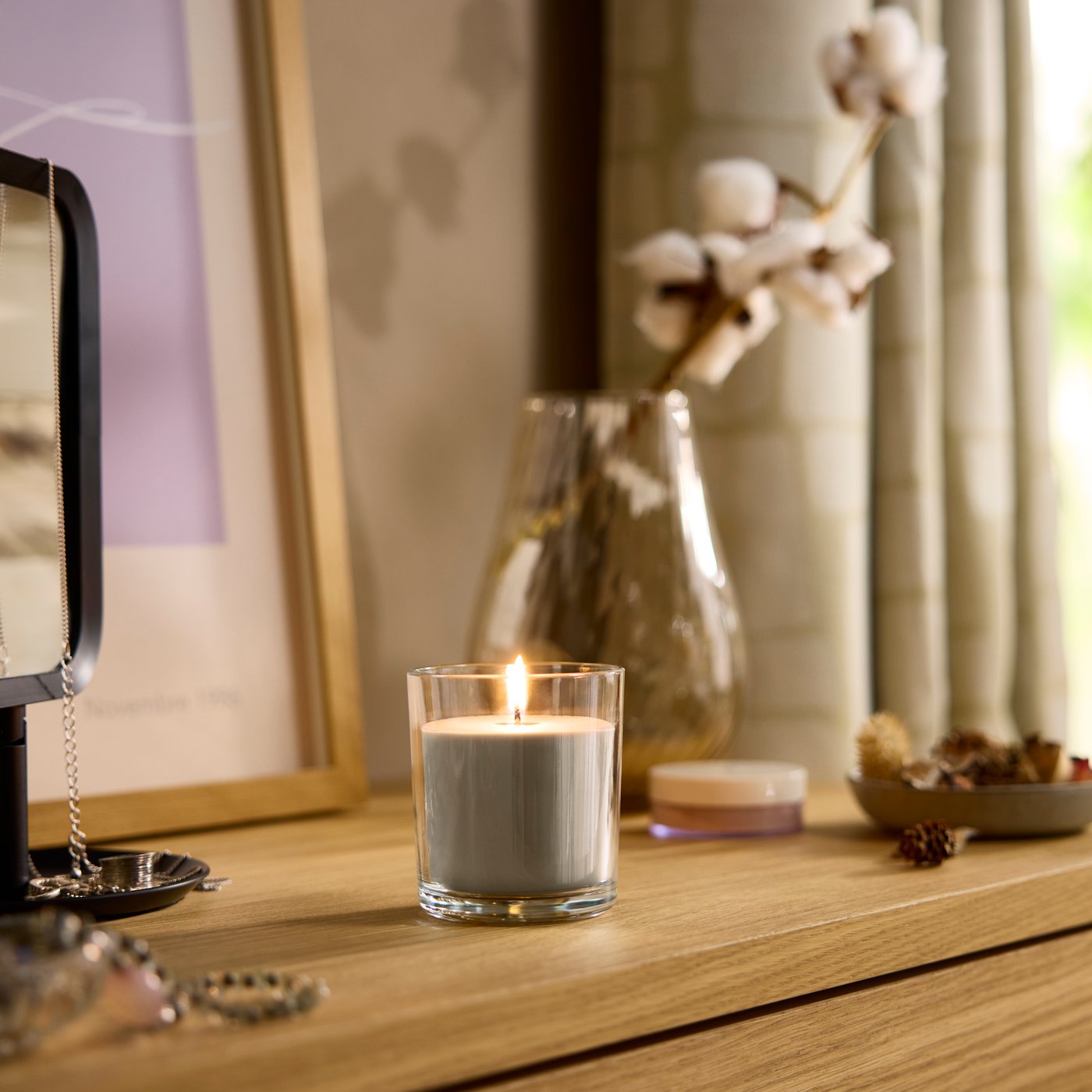 A Sandalwood & patchouli brown LOTSFÅGEL scented candle in glass in the bedroom