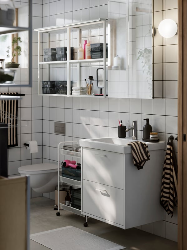 A modern small bathroom with white HAVBÄCK storage, LETTAN mirror cabinet and white open ENHET shelves on the wall.