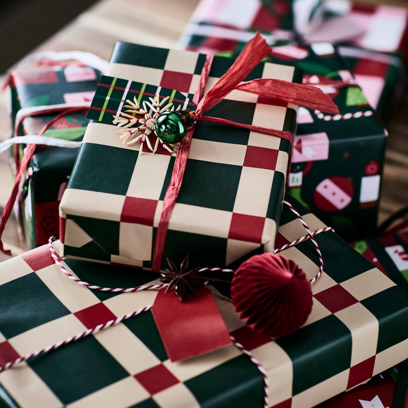 Christmas presents are festively wrapped in VINTERFINT gift wrappers with a bold green and red checkered pattern.