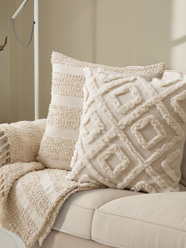 A natural GÖLSTARR cushion cover