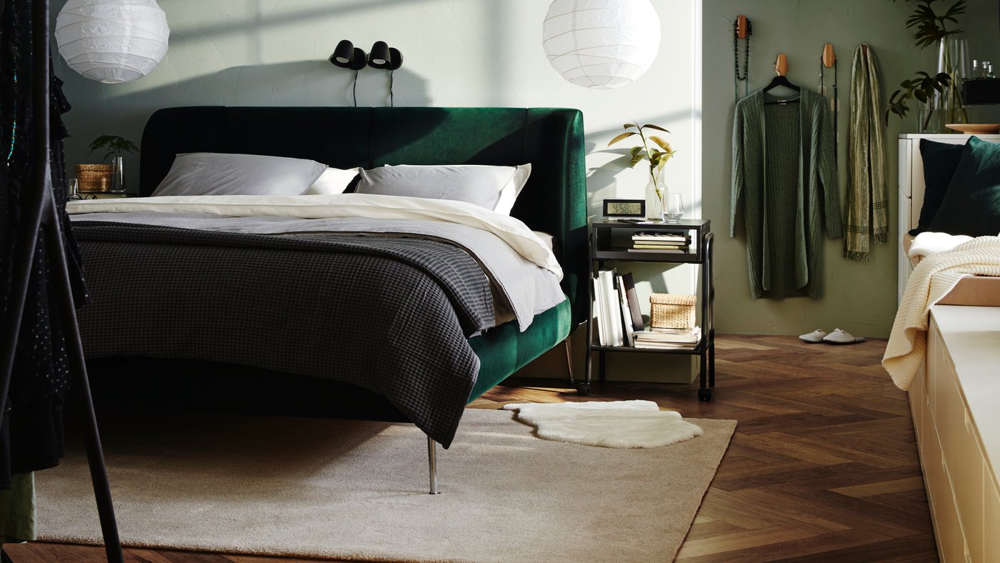 A black SKURUP wall lamp in the bedroom