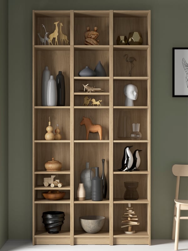 A BILLY bookcase combination with extension units in oak effect with decorative objects and vases on the shelves.