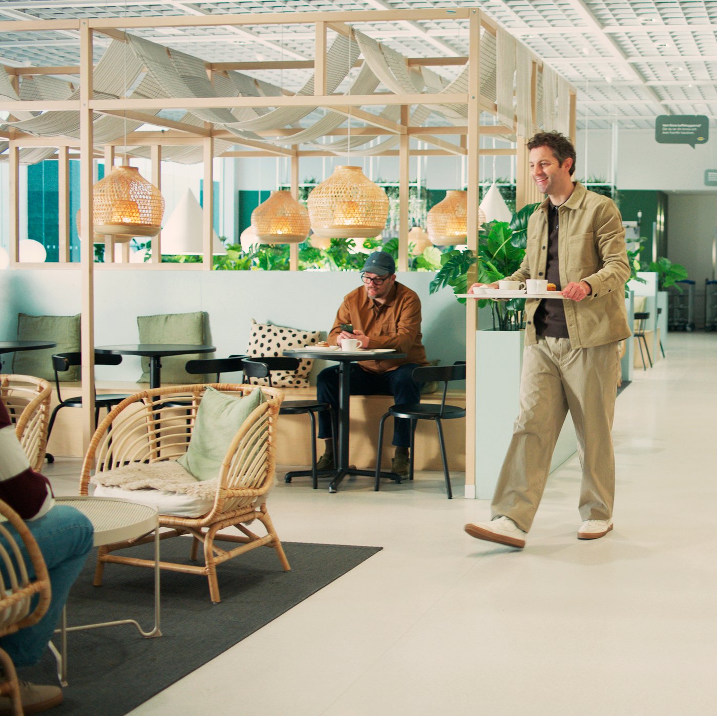 A man is carrying a tray in the IKEA restaurant.