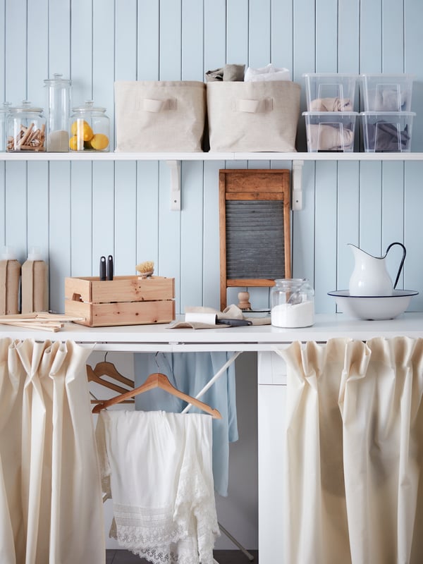 A clear glass VARDAGEN jar with lid in the laundry room