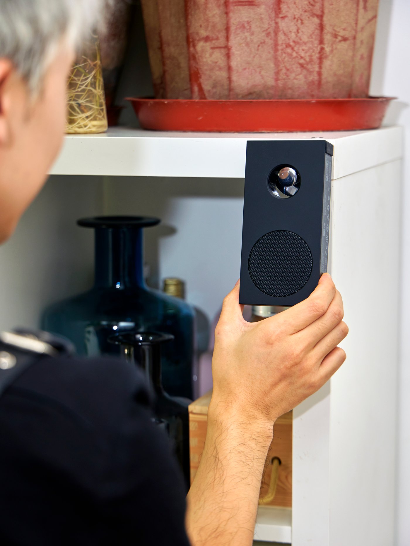 A person is holding an ENEBY portable bluetooth speaker.