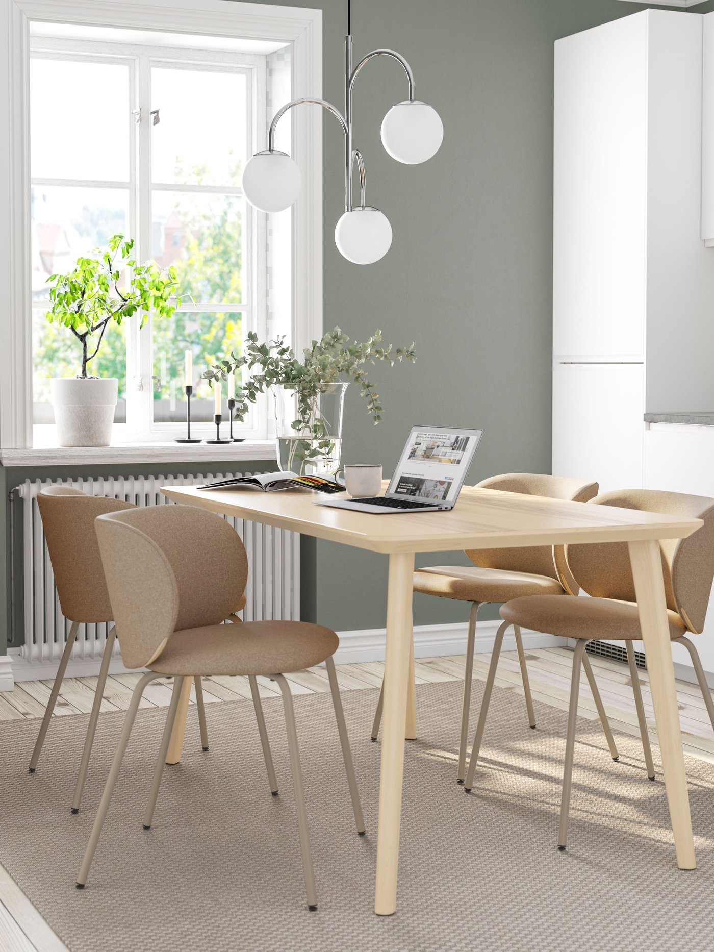 Una mesa de comedor LISABO con cuatro sillas KRYLBO. Sobre la mesa un notebook.