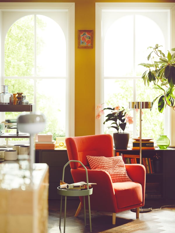 A retro living room with yellow walls and a striking OSKARSHAMN armchair.