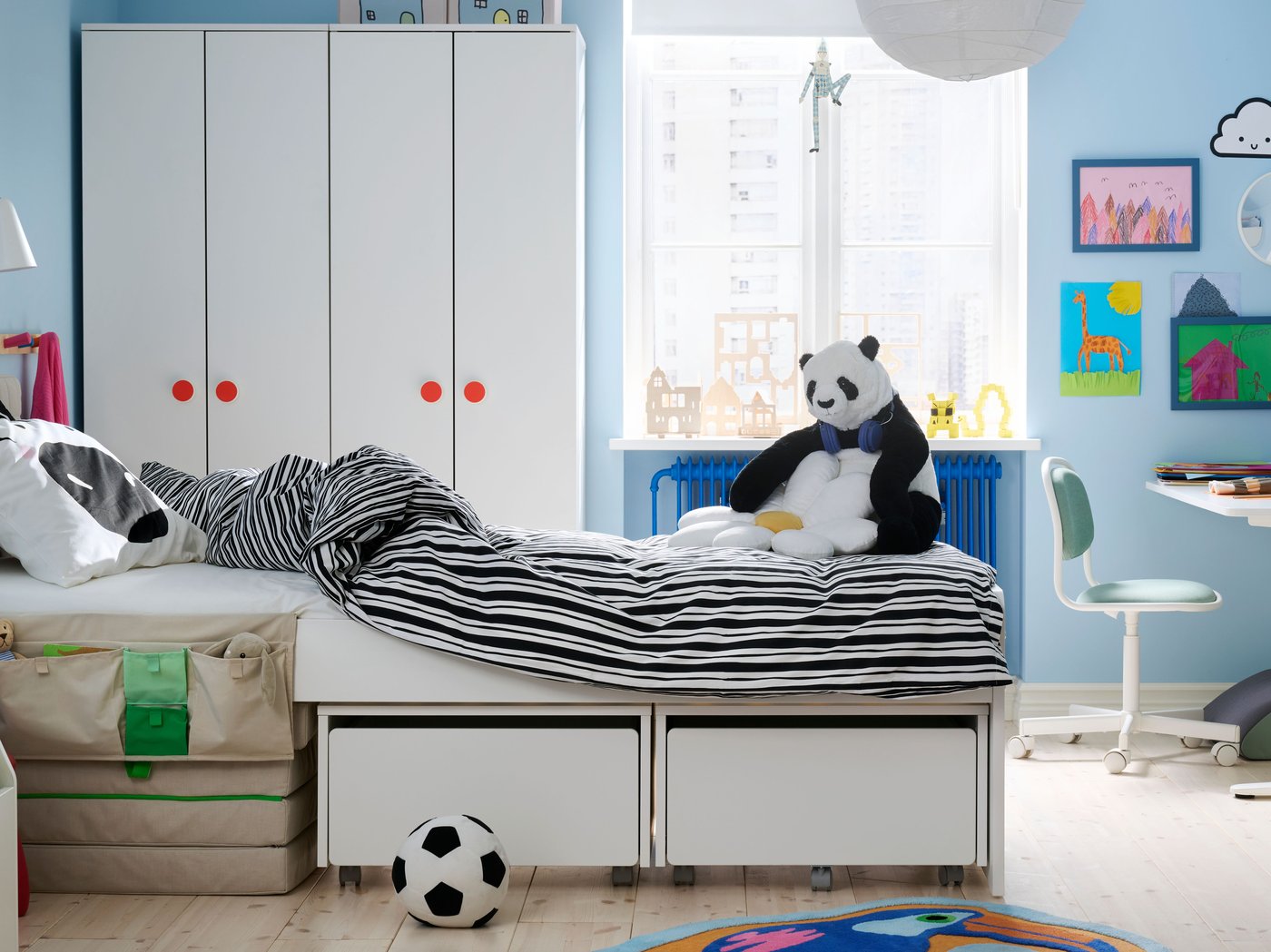 A children’s room with the SLÄKT bed in the middle made up with NATTHÄGER bedding, Wardrobes and window in background.