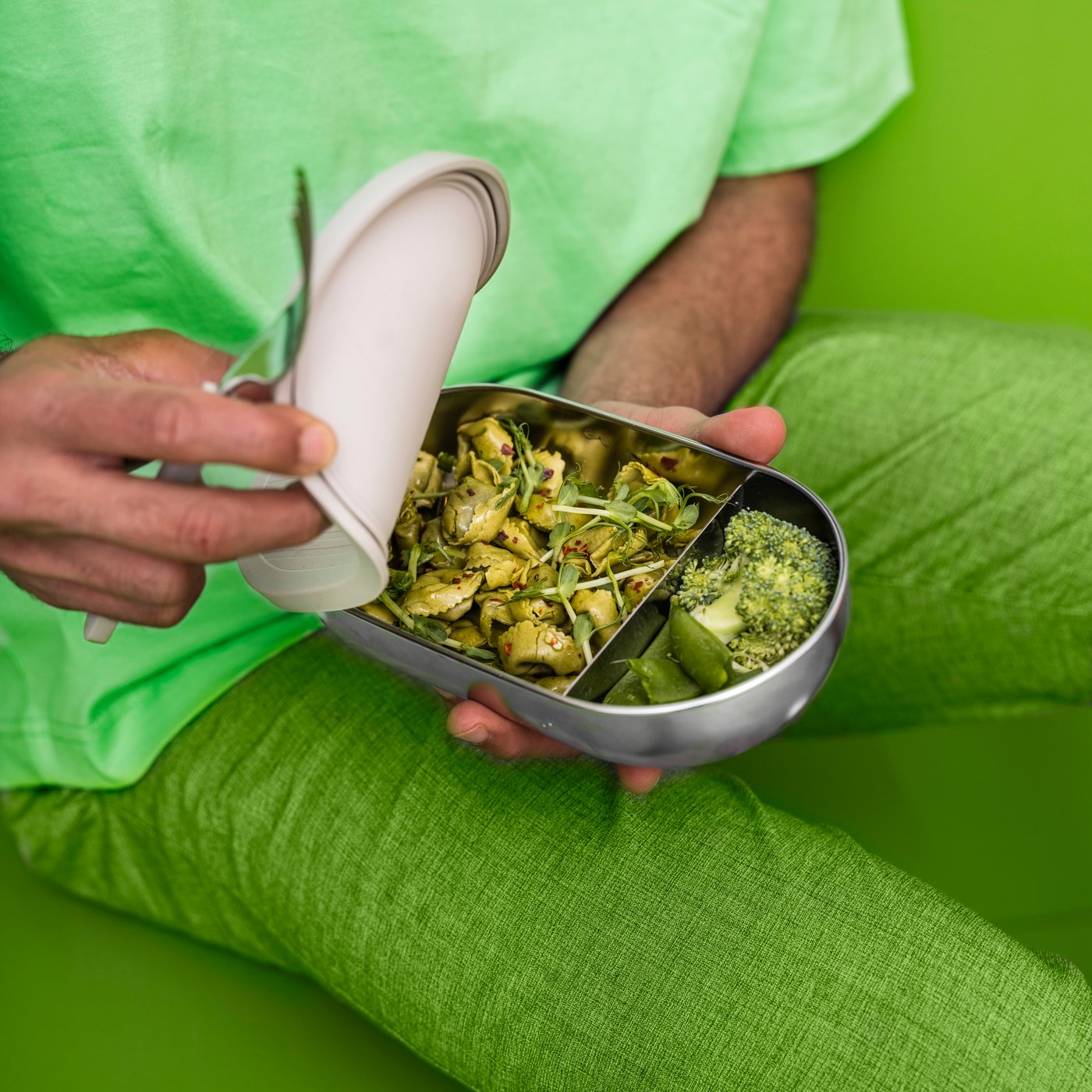 A stainless steel/beige HALVVARM food container w lid and divider