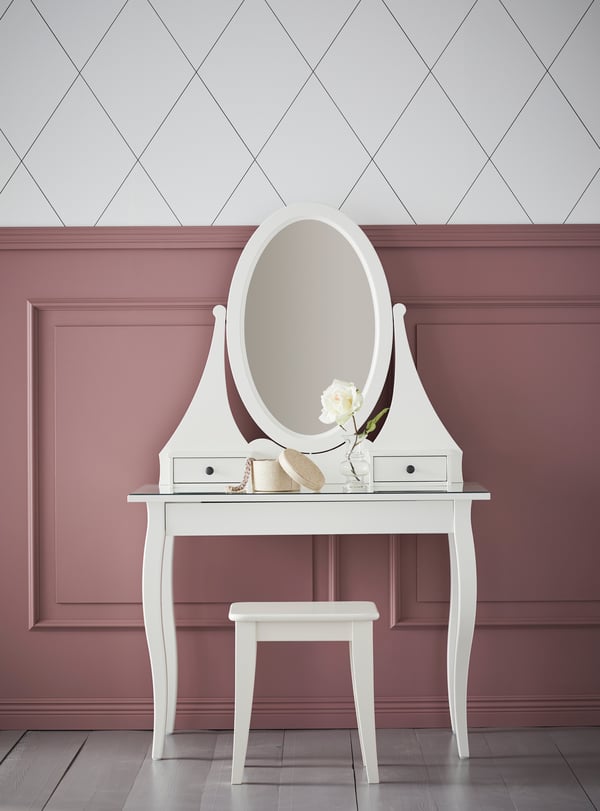 HEMNES white dressing table with matching mirror and stool by a pink wall.