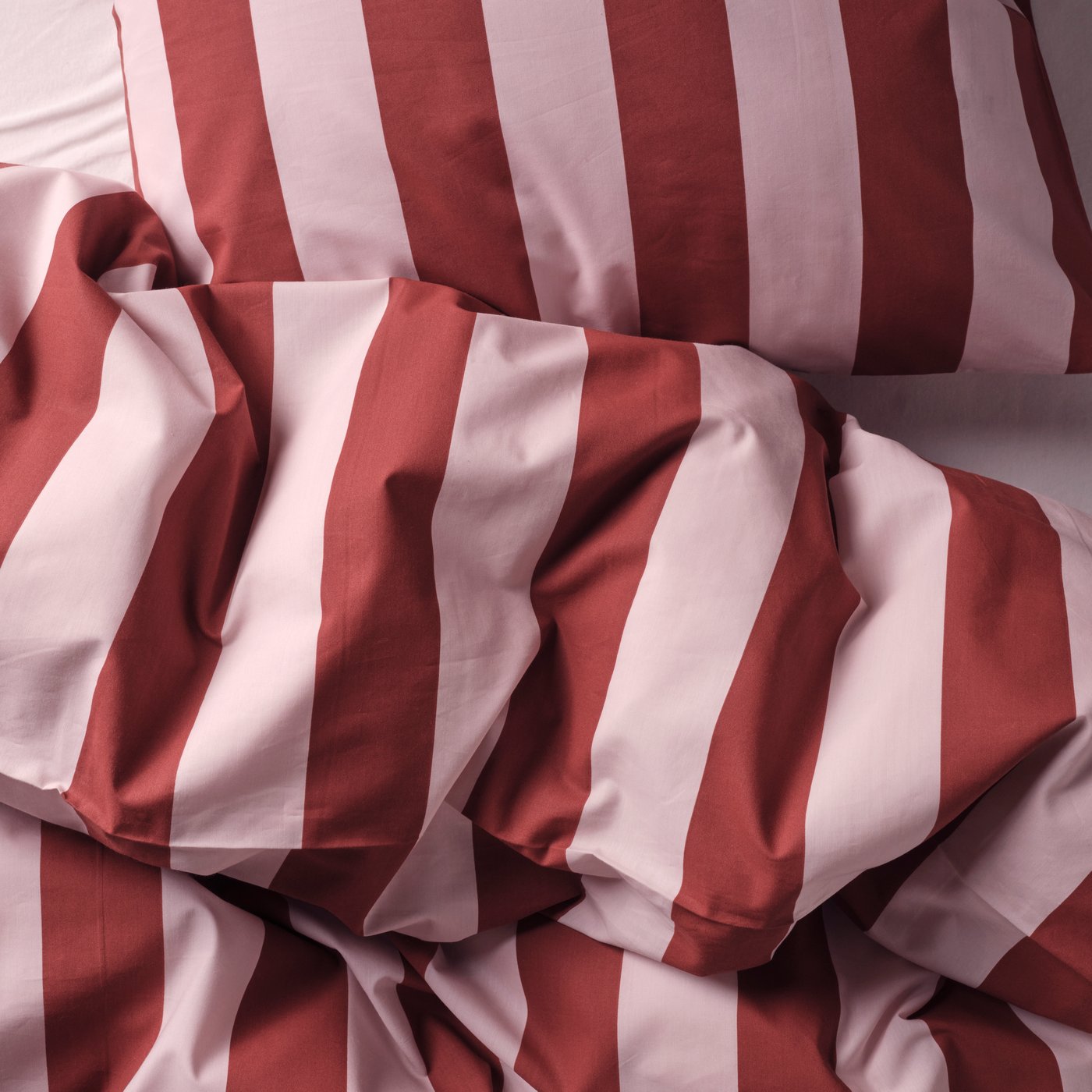 A light pink dark red/stripe SLÅNHÖSTMAL duvet cover and pillowcase in the NA
