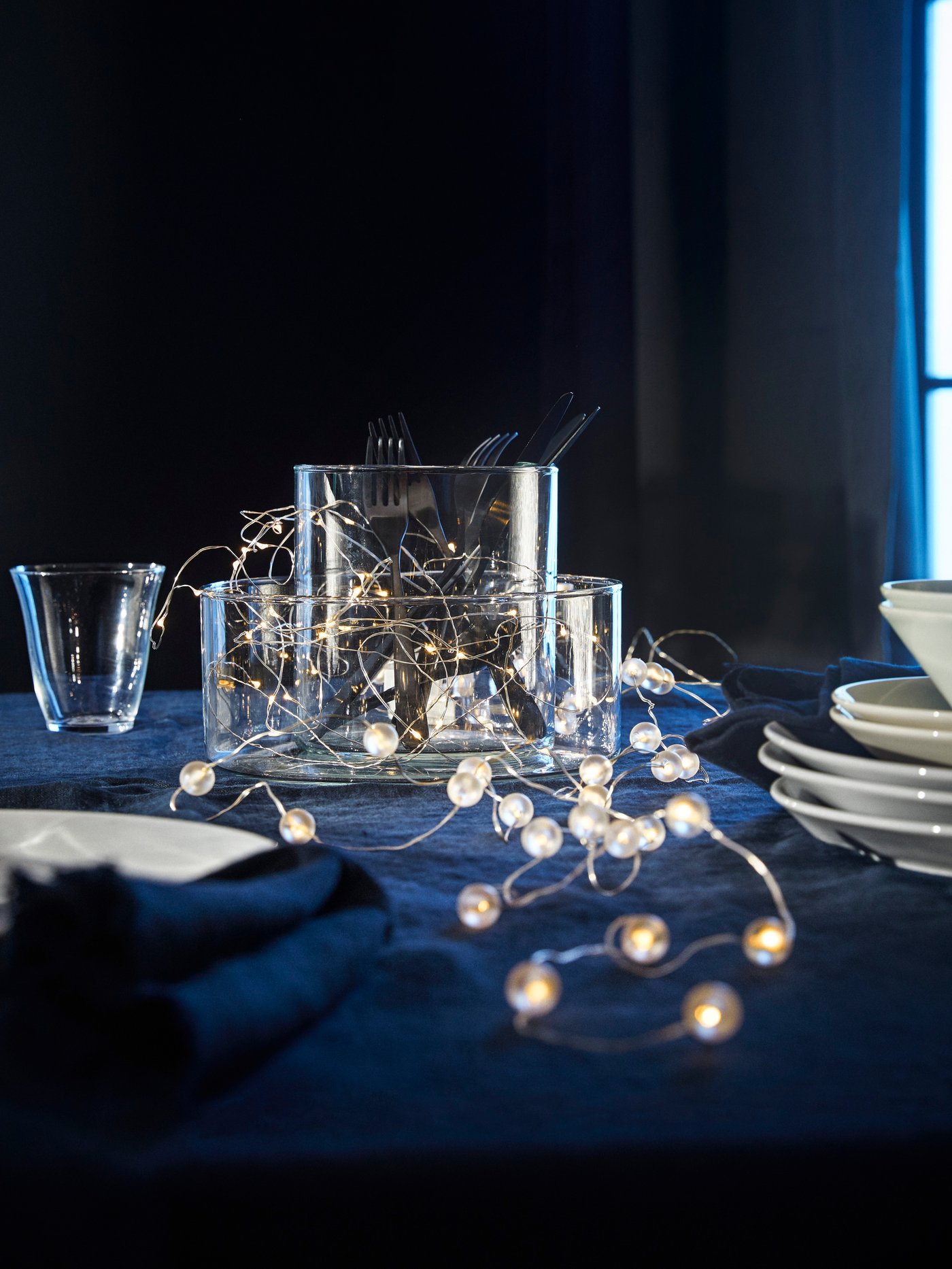 Een zilverkleurige SNÖYRA LED-lichtketting voor binnengebruik op batterijen met 40 lampjes in de eetkamer.
