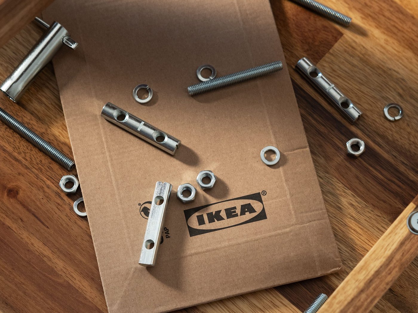 Spare part and tools spreaded on the floor on top of a flat cardboard box