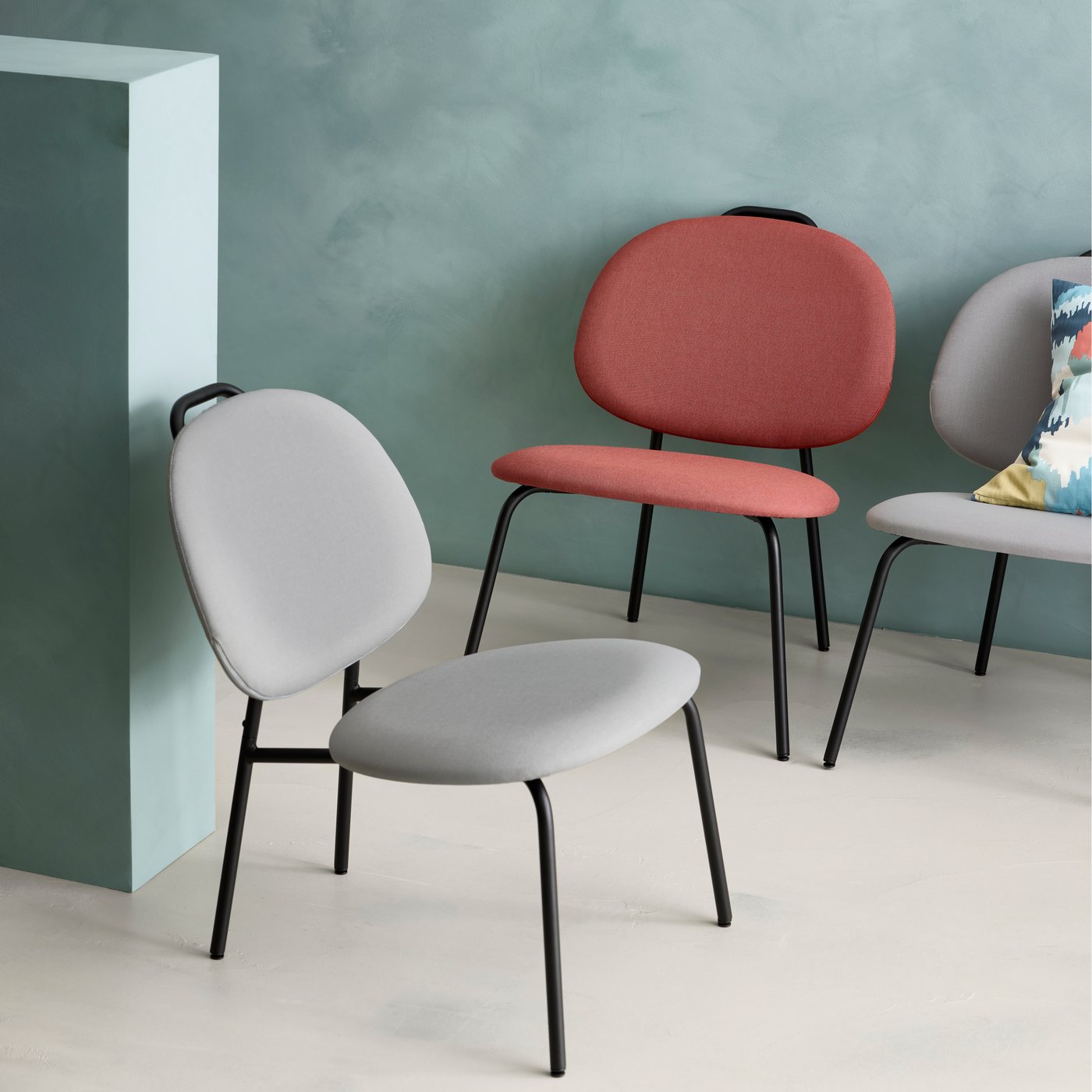 Close up of three GÄVLE easy chairs in grey and red.
