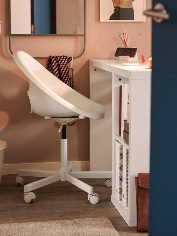 A small home workspace in the corner of a room with a white LOBERGET/MALSKÄR swivel chair by a white desk.
