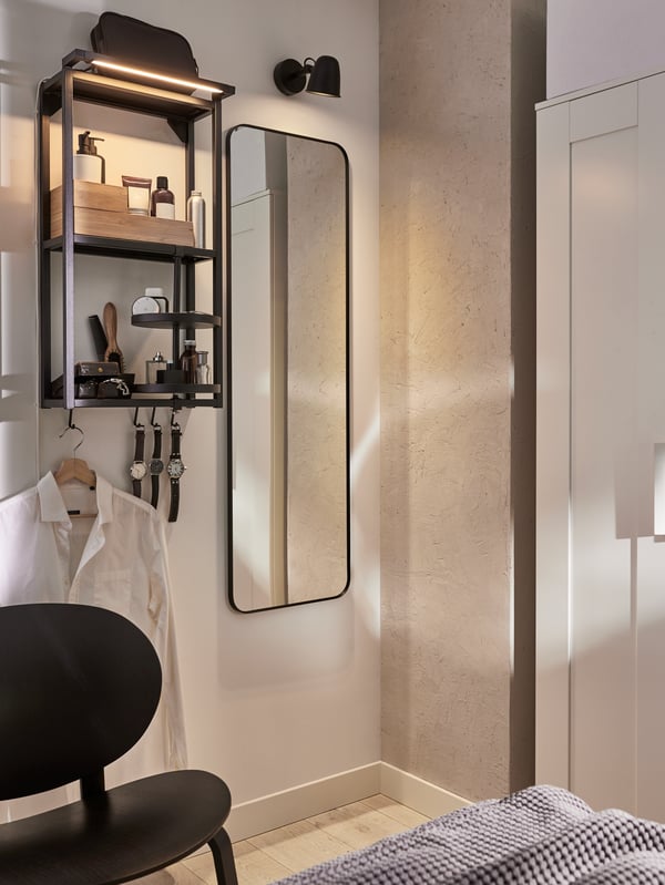 A black SKURUP wall lamp in the bedroom