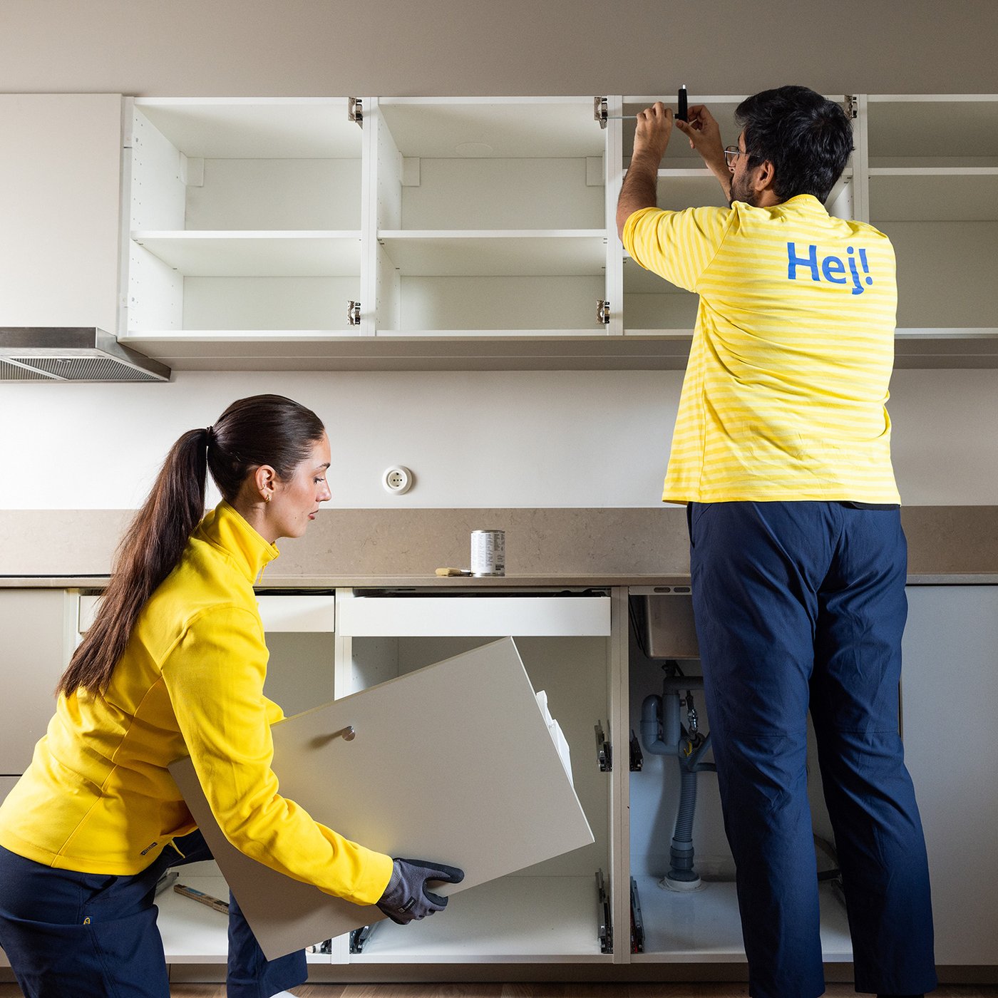 Dva IKEA zaposlena montiraju kuhinjske elemente.