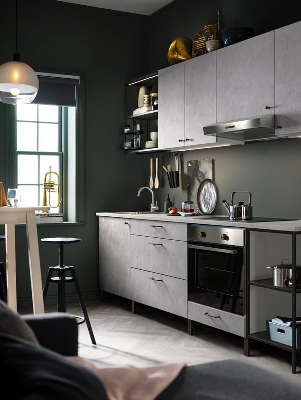 Une cuisine avec des rangements pour cuisine ENHET, un four GÖRLIG en acier inoxydable et une suspension JAKOBSBYN suspendue au-dessus.