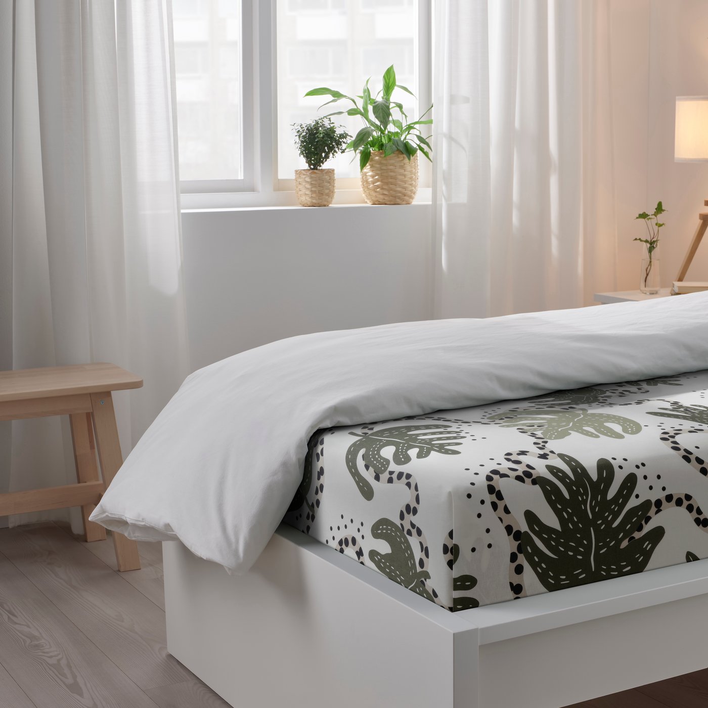 Una sábana plana y una funda de cojín KLÄTTERKALLA en blanco/verde.
