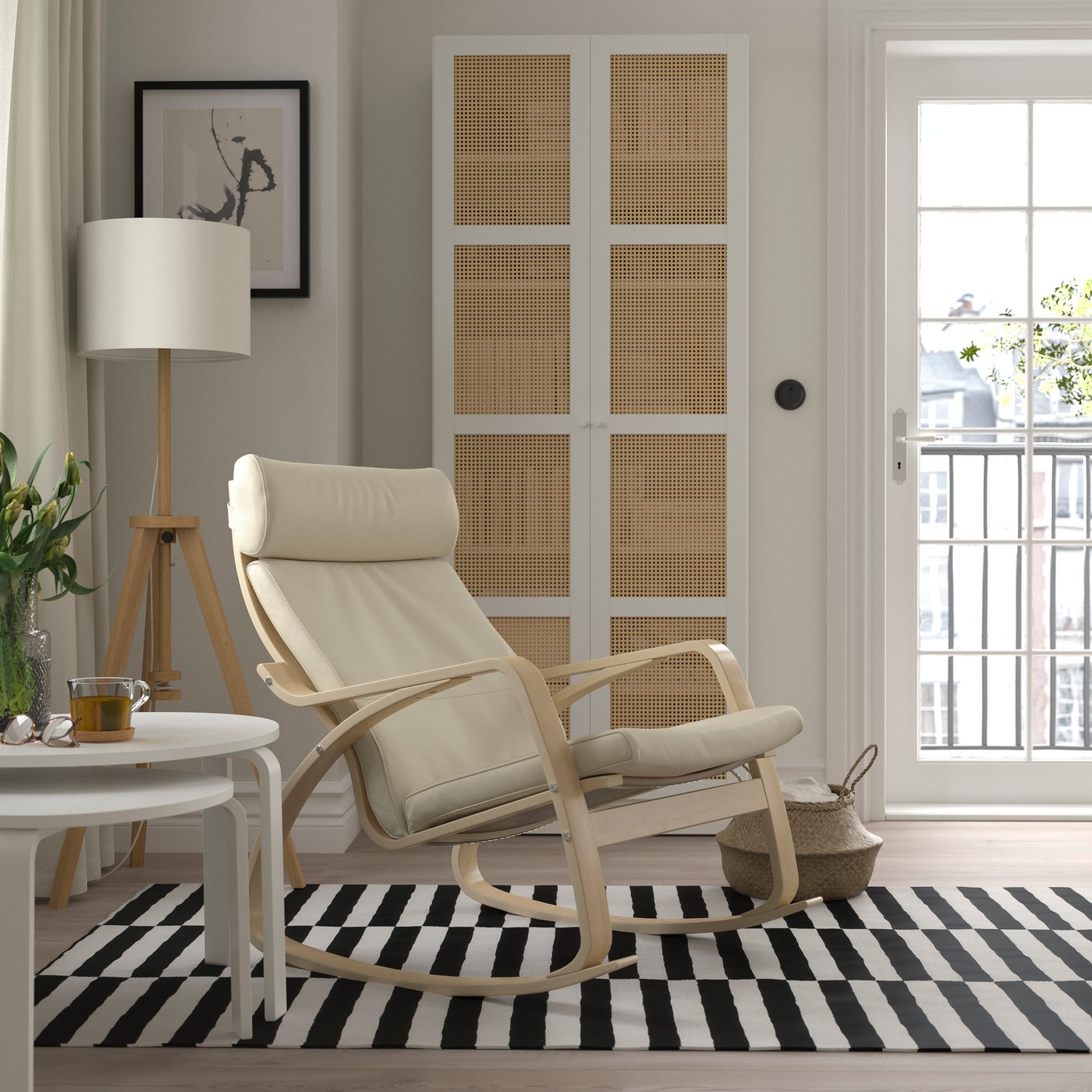 A POÄNG rocking chair in birch veneer on a black-and-white striped STOCKHOLM rug.