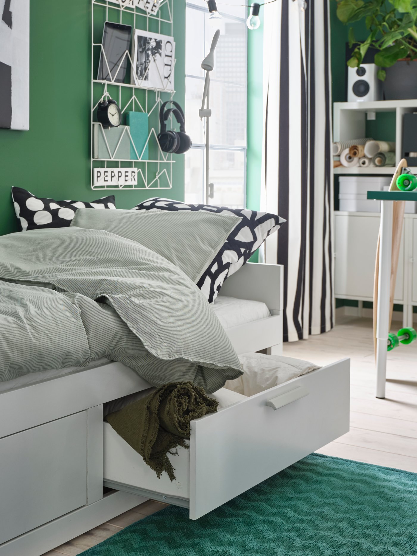 A BRIMNES daybed with drawers in a teen room with green walls.