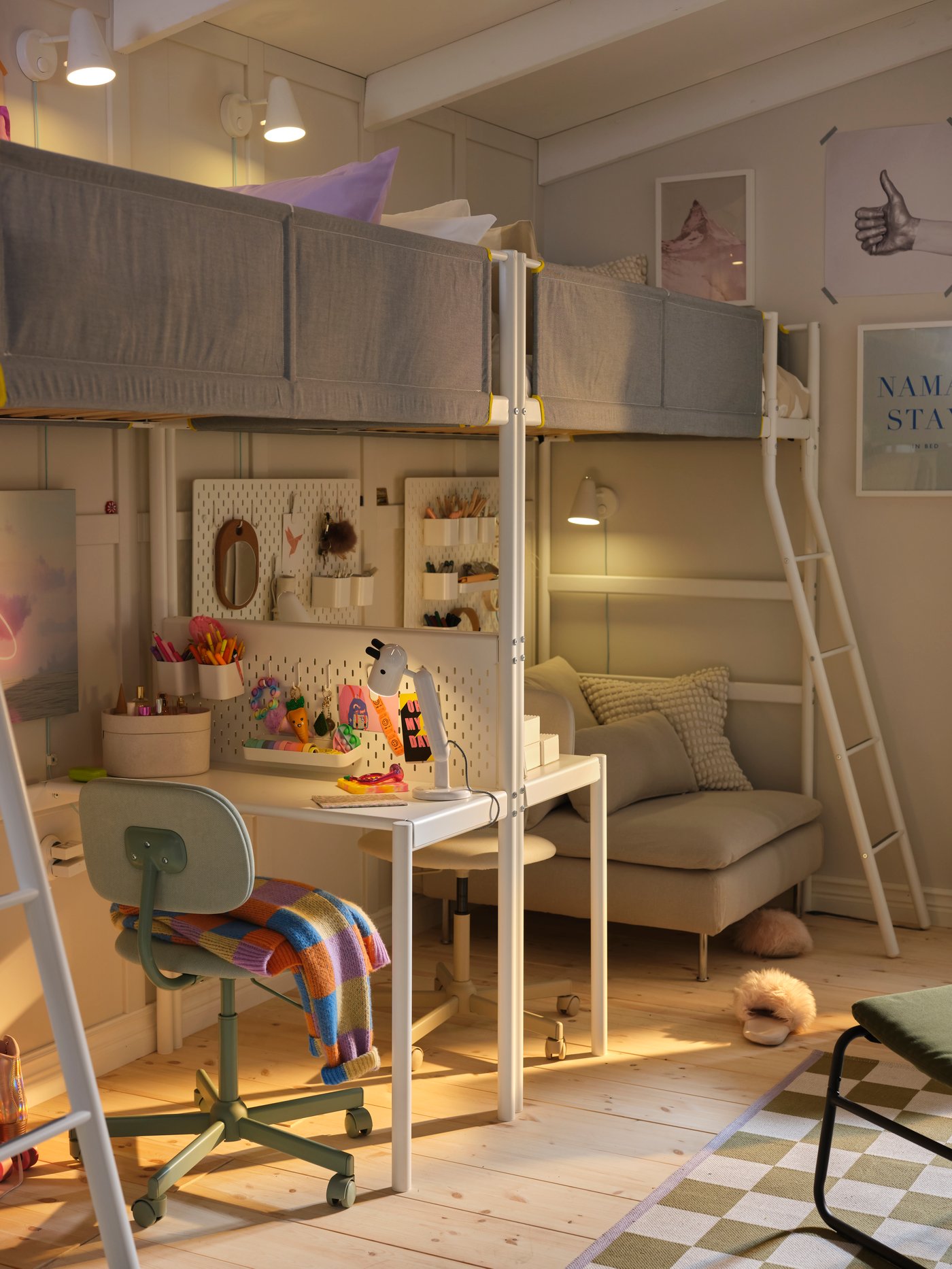 Deux structures de lit mezzanine avec plateau de table VITVAL le long d’un mur beige. Un module de canapé beige se trouve en dessous.