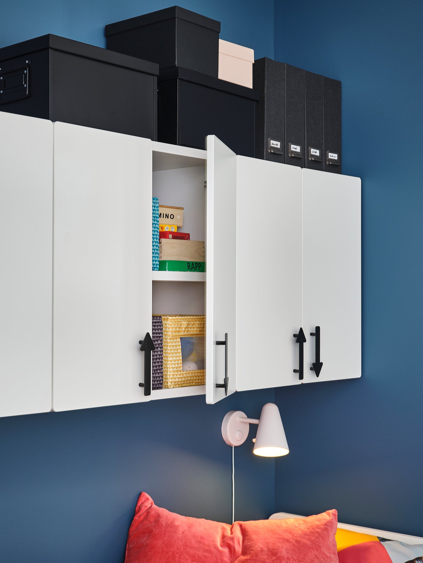 SMÅSTAD cabinets with JÄRNSPARV handles are mounted on a blue wall, and different boxes and magazine files sit on top.