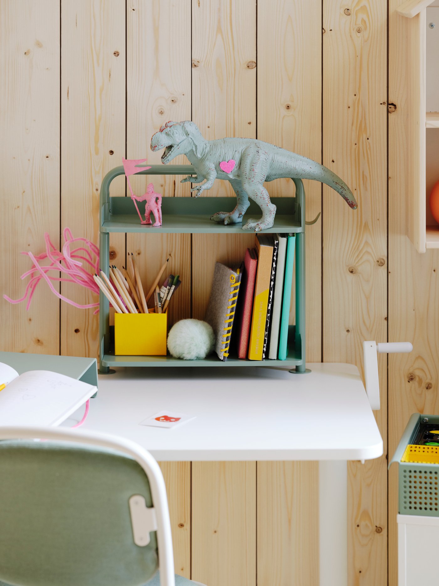 Un estante organizador de escritorio ÖVNING con libros, cuadernos y lápices.