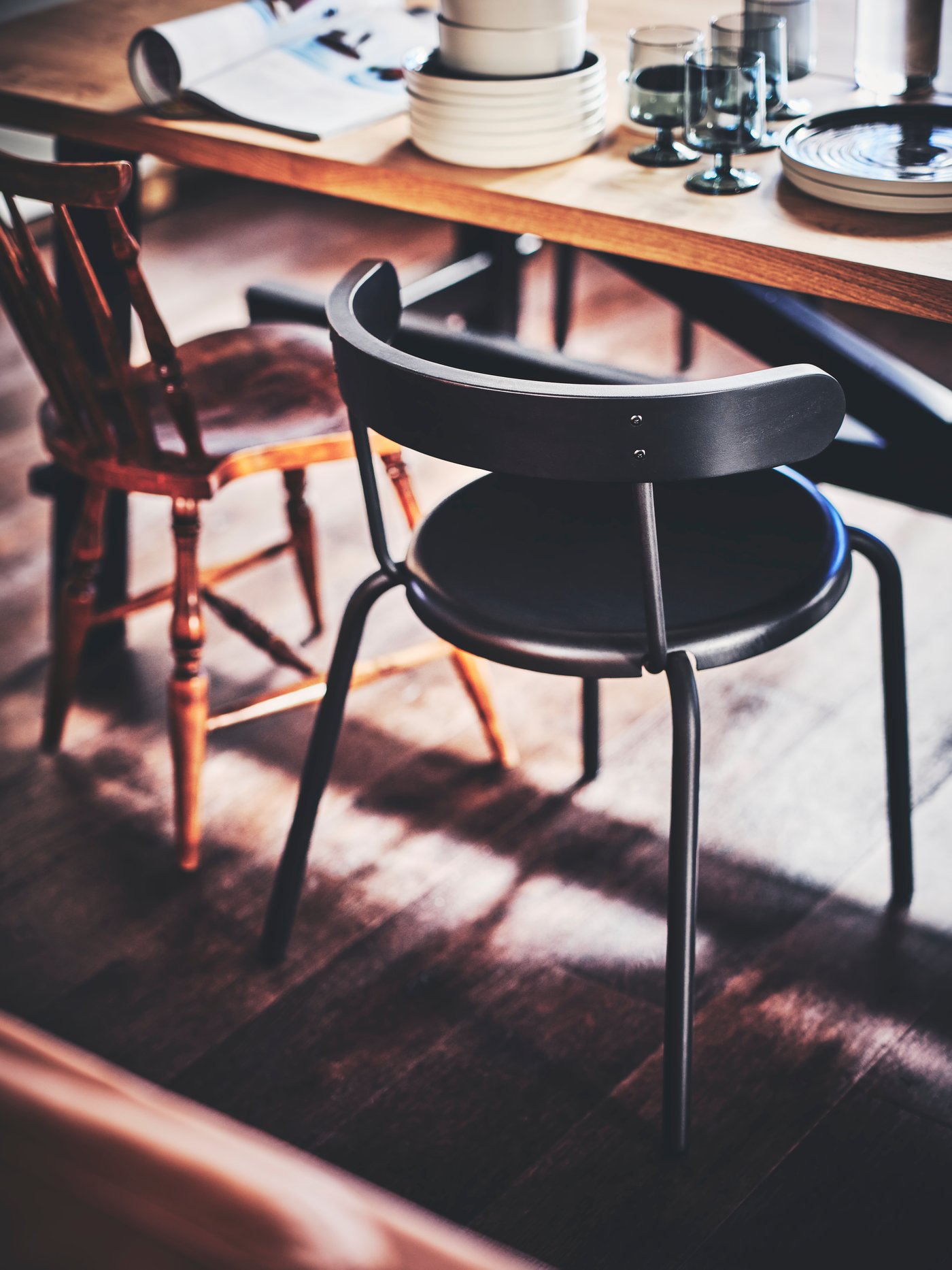 A SKOGSTA dining table in an acacia wood look and a black YNGVAR bar stool.