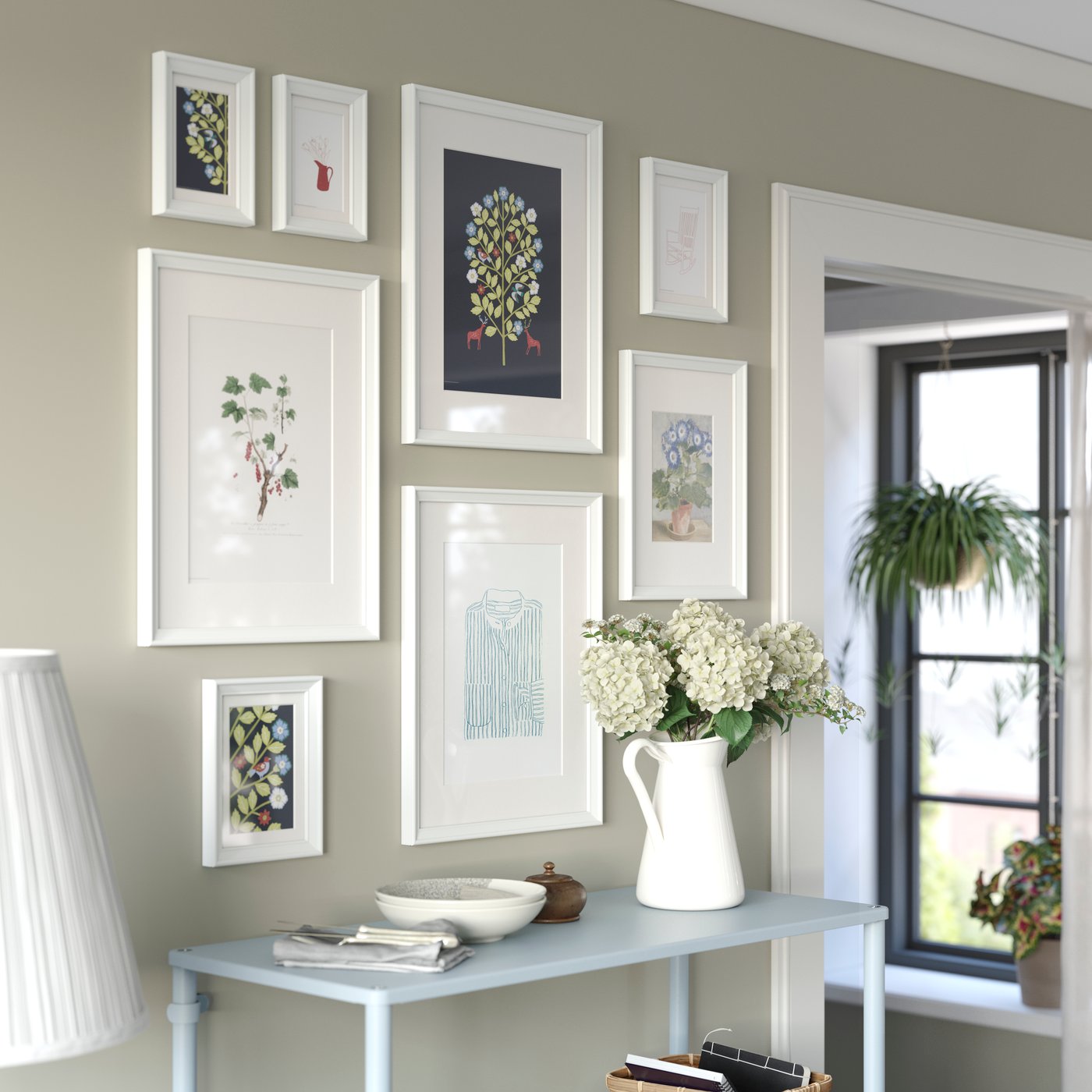 Espacio luminoso con una composición ordenada de pósters KNOPPÄNG en diferentes tamaños, colocados en marcos sobre una pared.