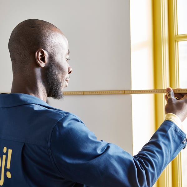 An IKEA installer measuring a customers kitchen.