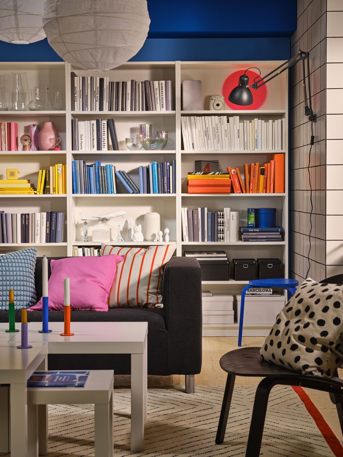 Ein buntes Zimmer mit weißen Bücherregalen im Hintergrund.