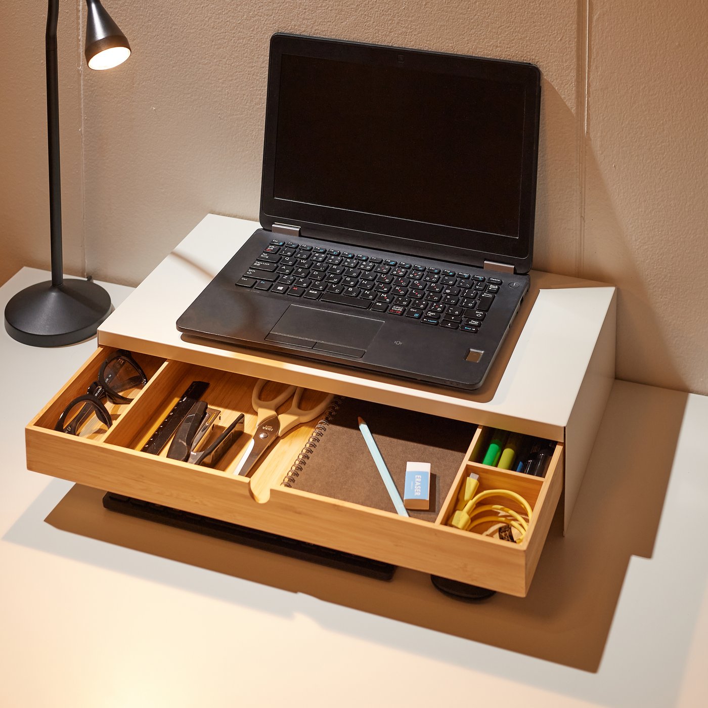 A white ELLOVEN monitor stand with drawer