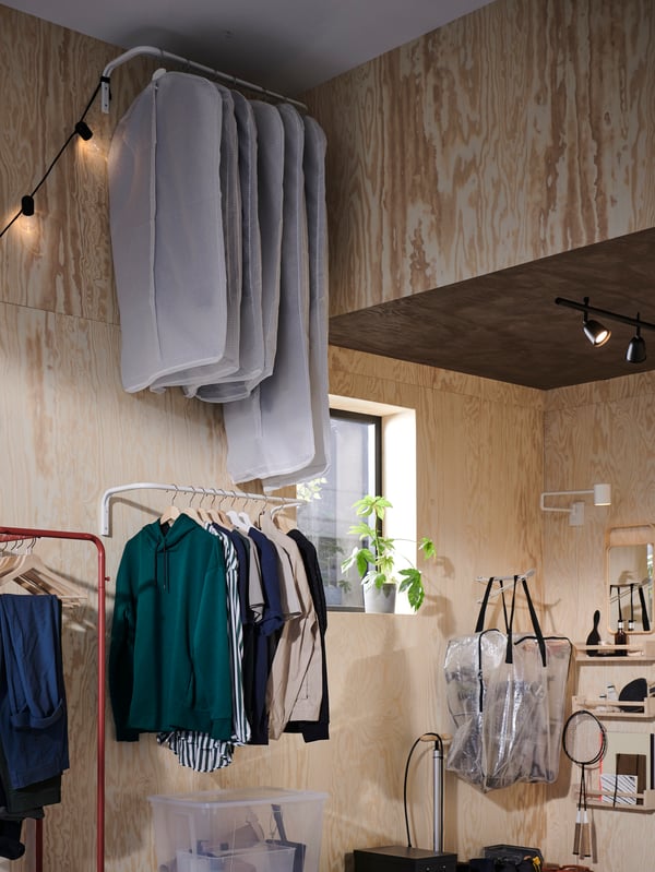 Two MULIG clothes bars filled with clothing on top of each other, with the top one holding clothing in STUK clothes covers.