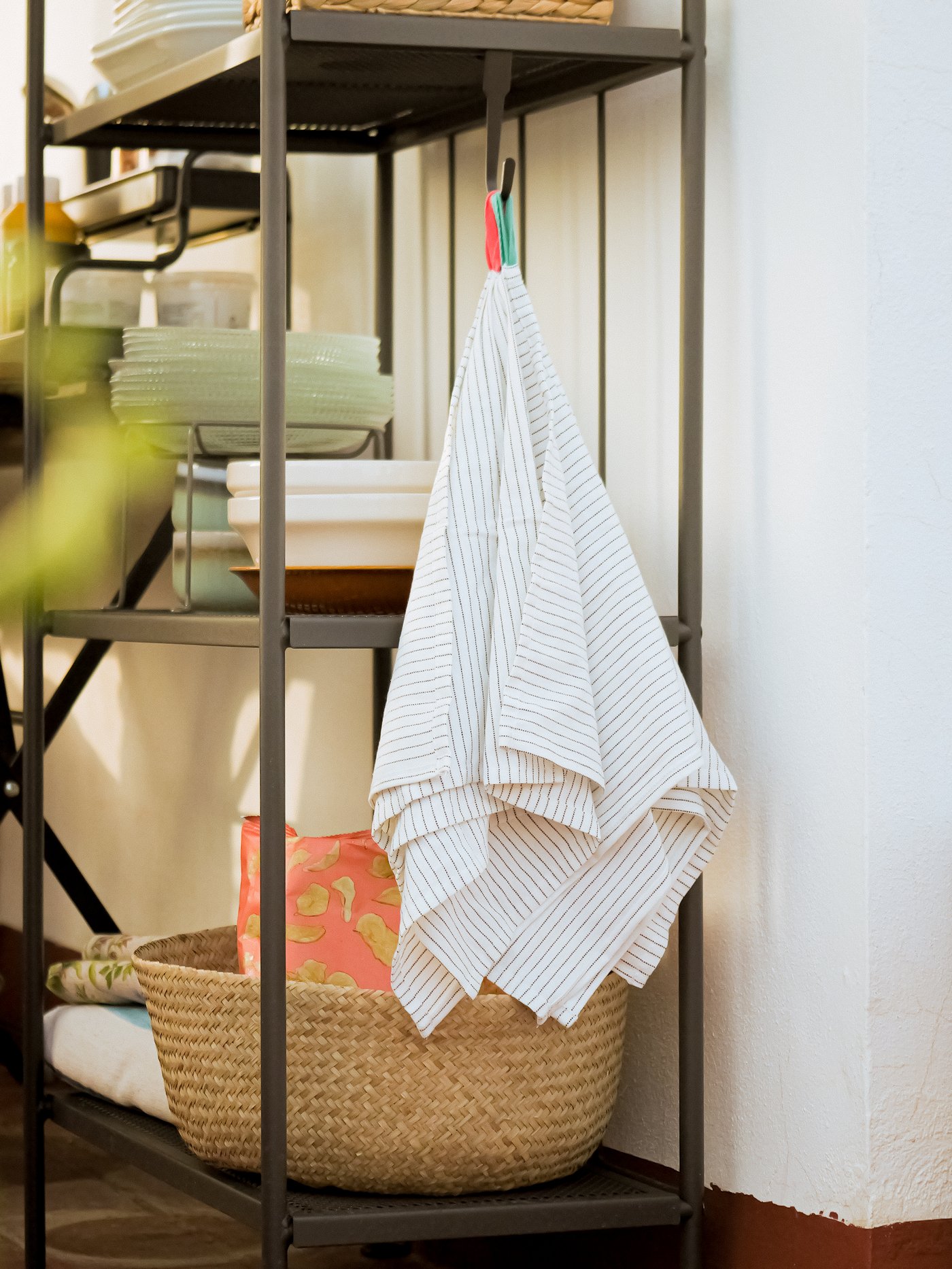A set of GRUPPERA napkins are hanging from a hook on a side table.