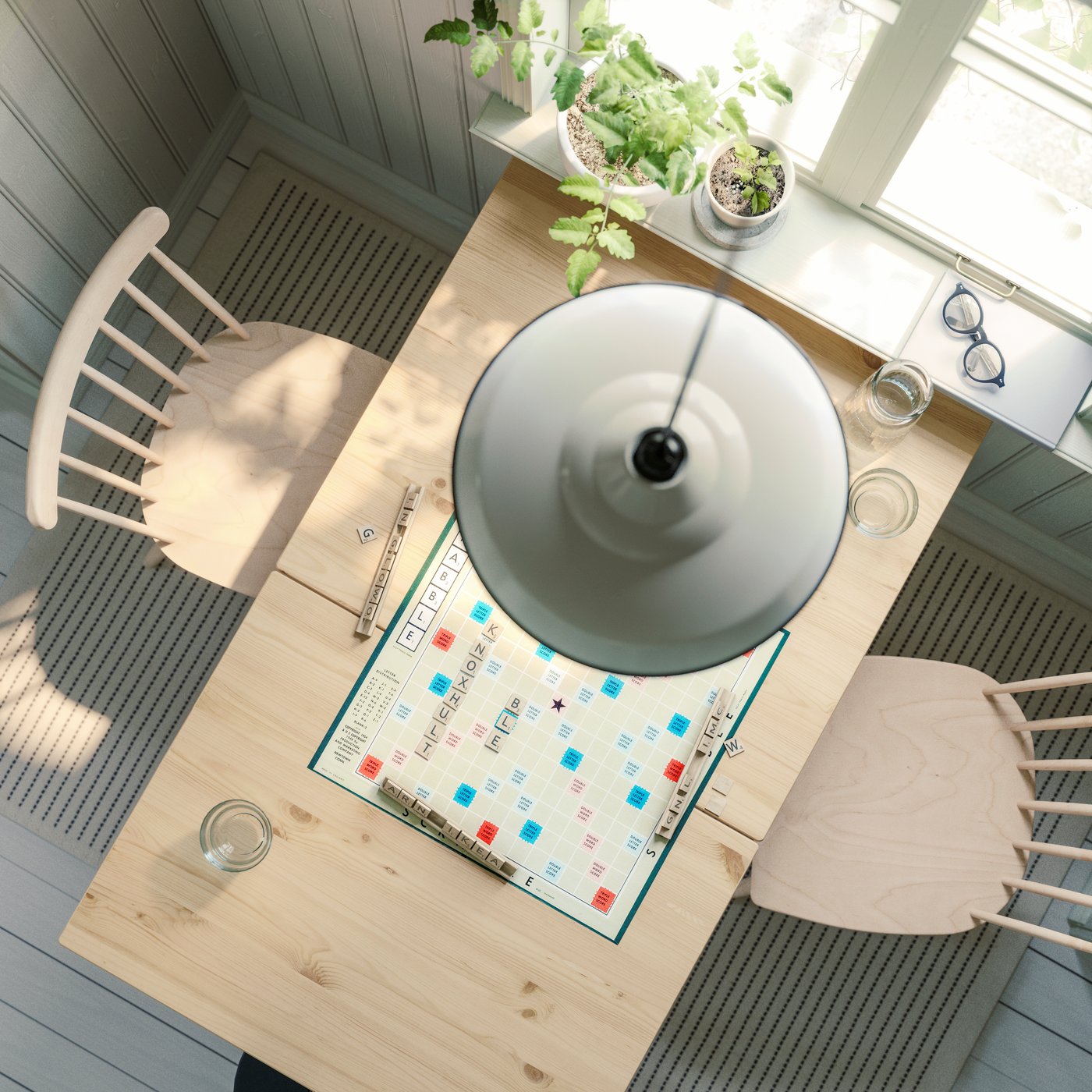 A light brown stained/white stained PINNTORP gateleg table, with two HÖGVED chairs in birch veneer, is seen from above.