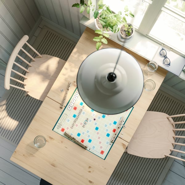 A light brown stained/white stained PINNTORP gateleg table, with two HÖGVED chairs in birch veneer, is seen from above.