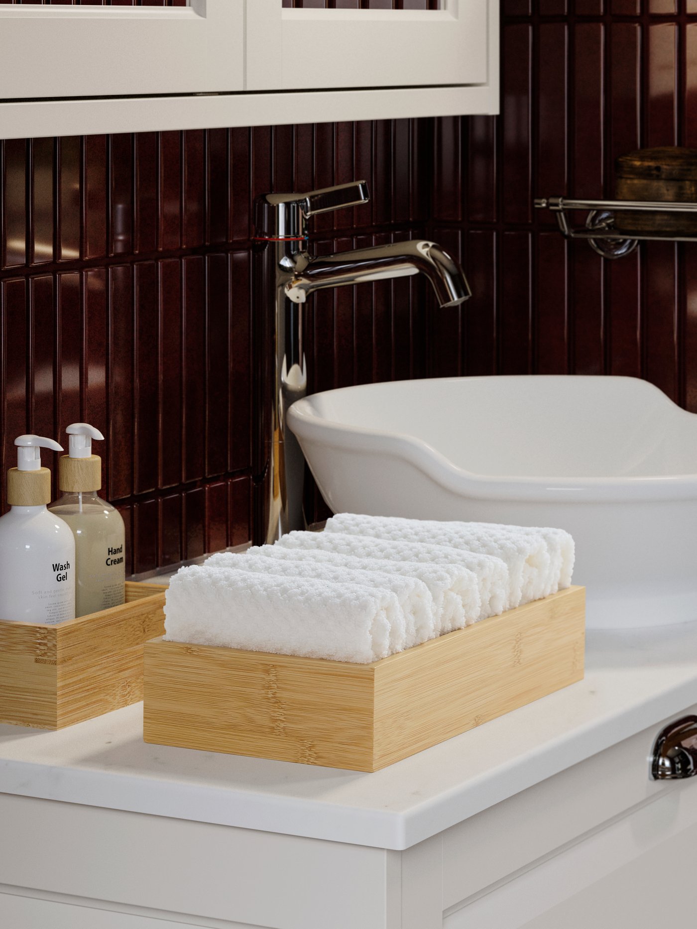 A bathroom sink with GULVIAL white washcloths neatly folded in a bamboo tray beside liquid soap and hand lotion bottles.