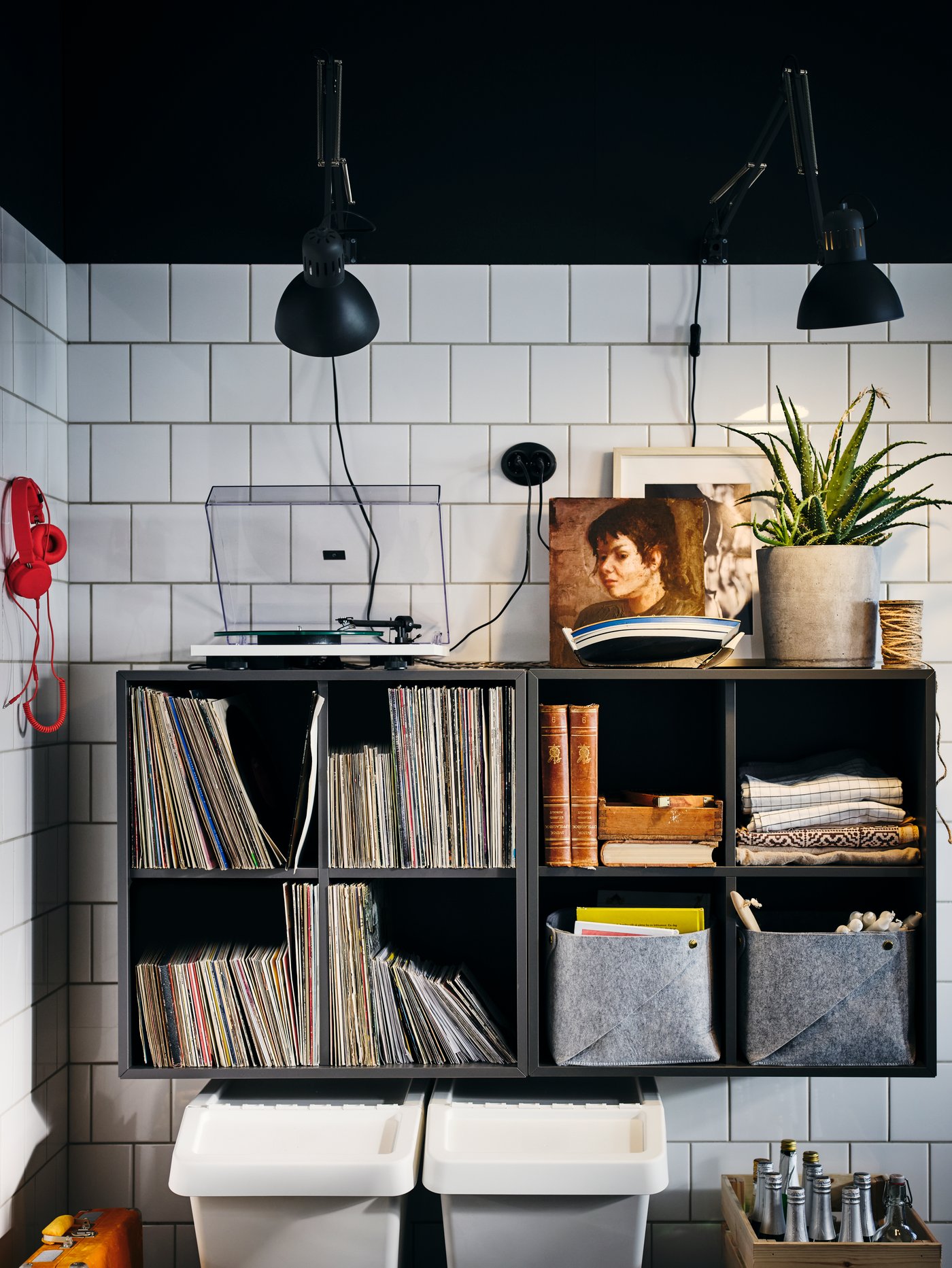 A white-tiled kitchen corner with side-by-side, wall-mounted, dark-grey EKET four-compartment cabinets.