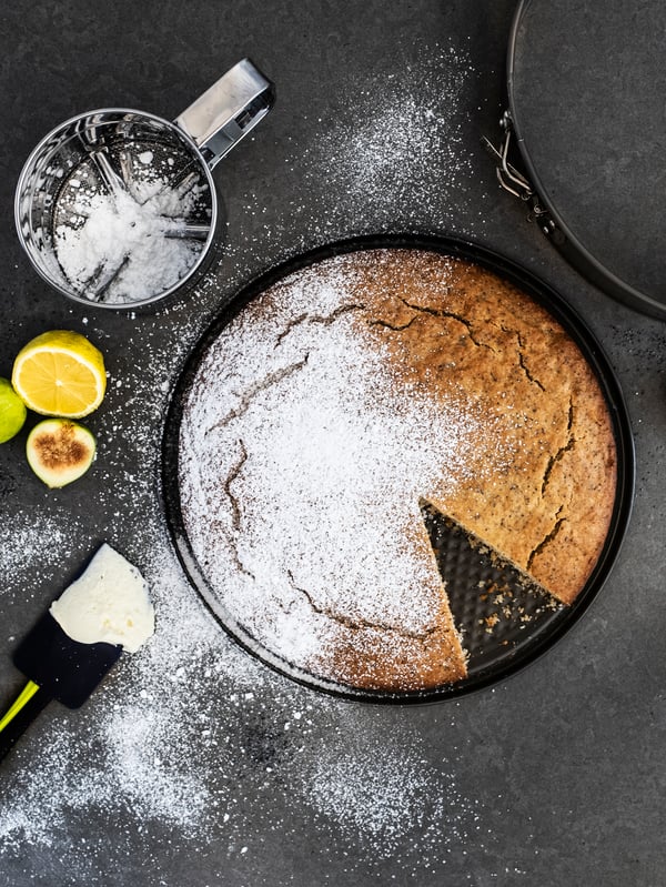 A person ices a cake on a BAKGLAD cake stand with a stainless steel LÄTTBAKAD offset spatula.