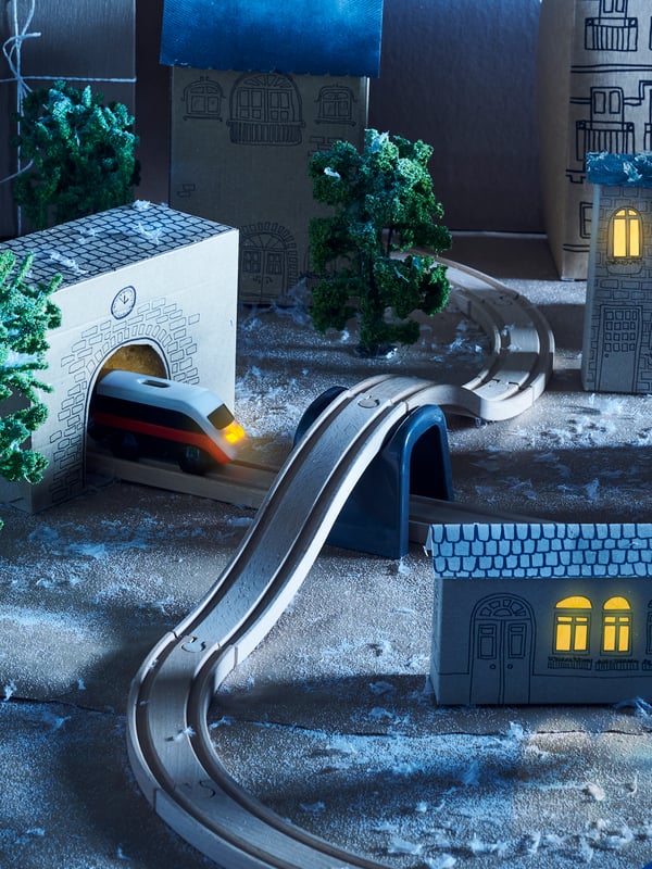 Diorama sela napravljena postavljanjem LILLABO osnovnog seta vozića od 20 delova s modelima zgrada i drveća.