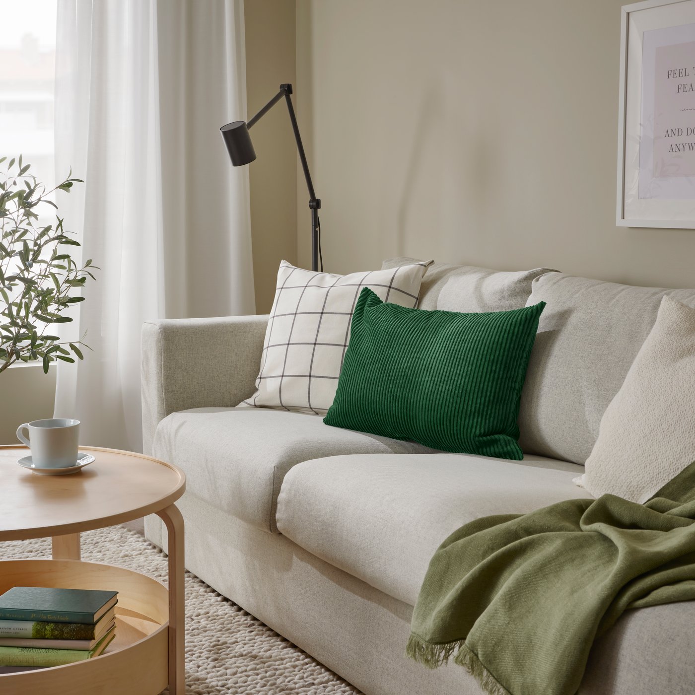 A dark green ÅSVEIG cushion cover
