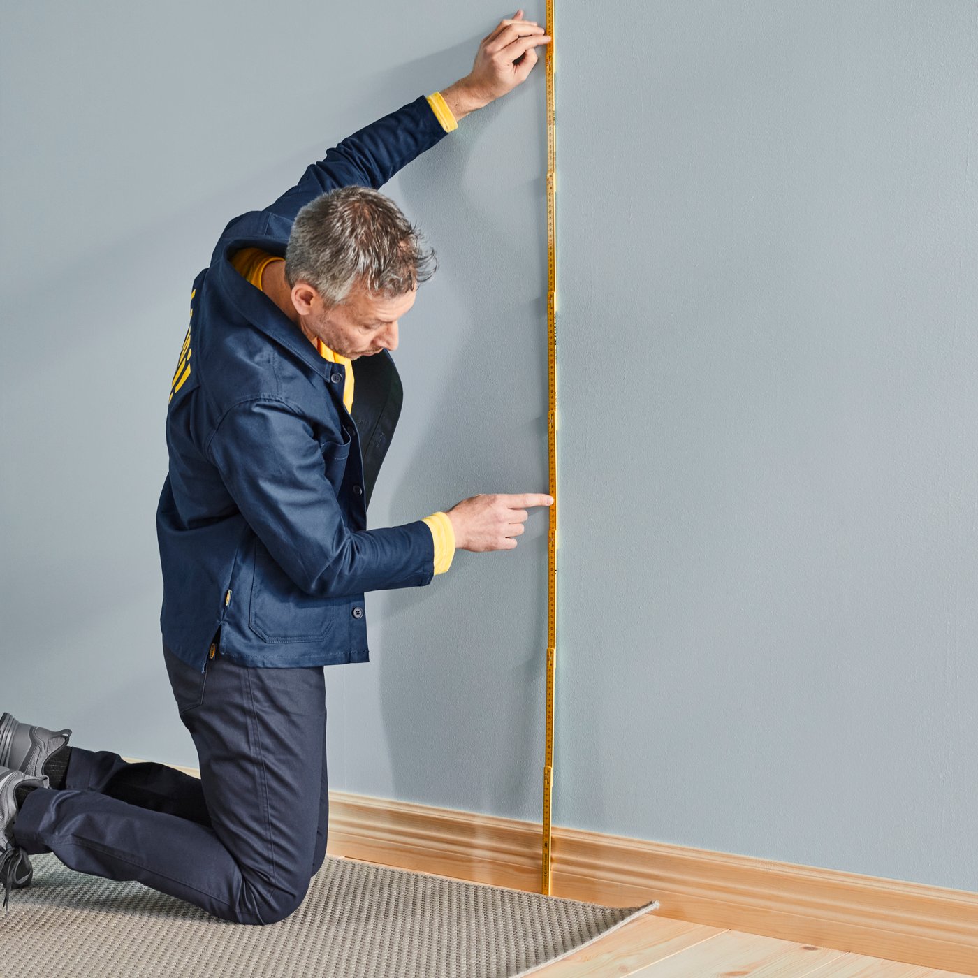 An IKEA co-worker measures up a bedroom wall